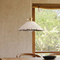 Plavo pendant light hanging over a timber dining table beside a garden window