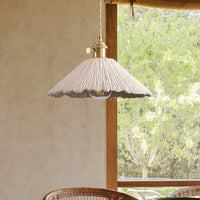 Plavo cement pendant against a warm plaster wall with a rattan chair below