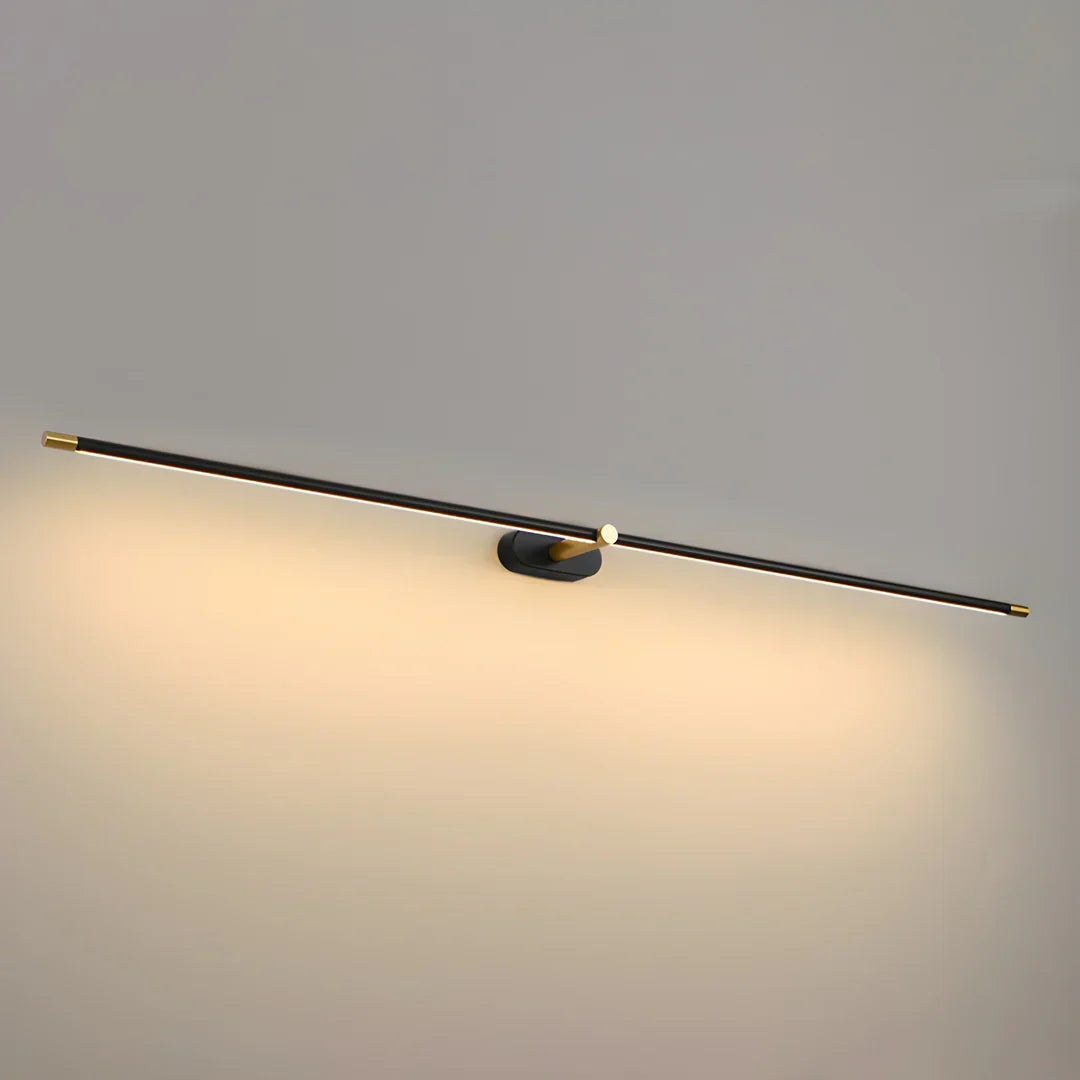 Close view of the Ivo wall light bar and gold hub with warm light washing the wall