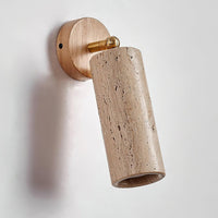 Sintra travertine wall sconce mounted on a plain white wall with the head tilted forwards
