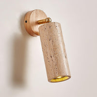 Sintra adjustable travertine wall light on a plain pale wall, beige stone cylinder on a pale wood backplate