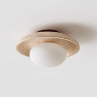 Angled view of the Renvo travertine flush mount light against a plain wall