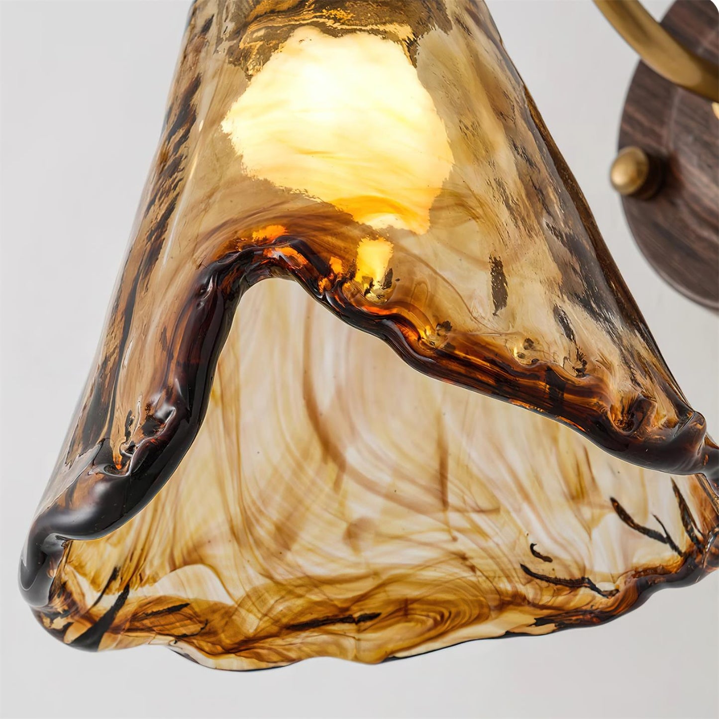 Close up of the swirled amber and brown glass shade on the Ambro wall sconce