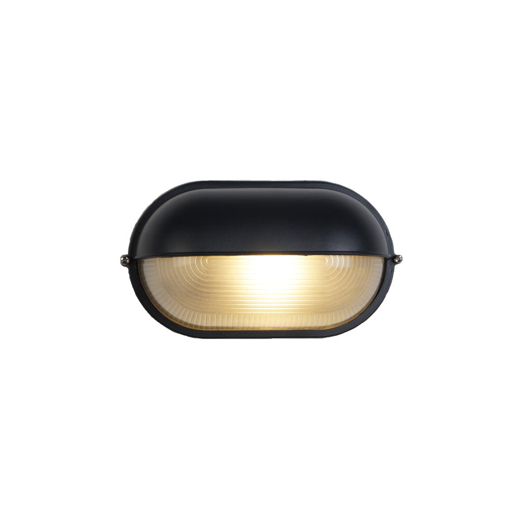 Lockhone Verrow industrial outdoor wall light, black oval bulkhead with ribbed glass lens, lit, on a plain white background