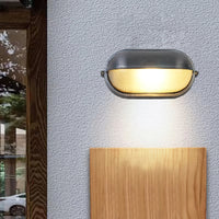 Estwin bulkhead light mounted beside a timber panel, casting light down the wall