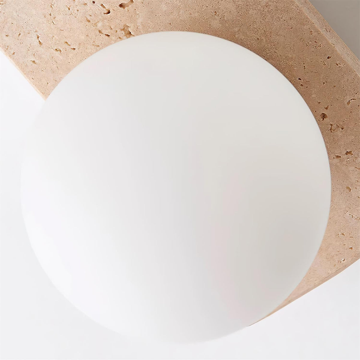Varro Travertine Wall Lamp - frosted glass globe against travertine body