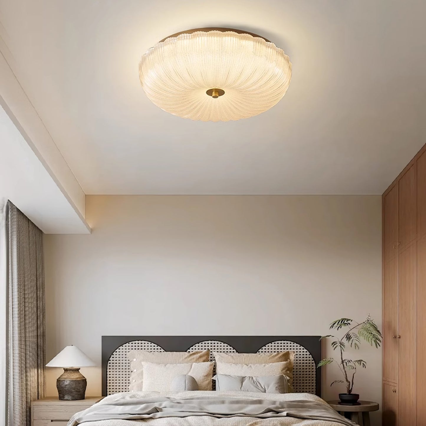 Hala ripple glass flush mount ceiling light lit above a rattan bed