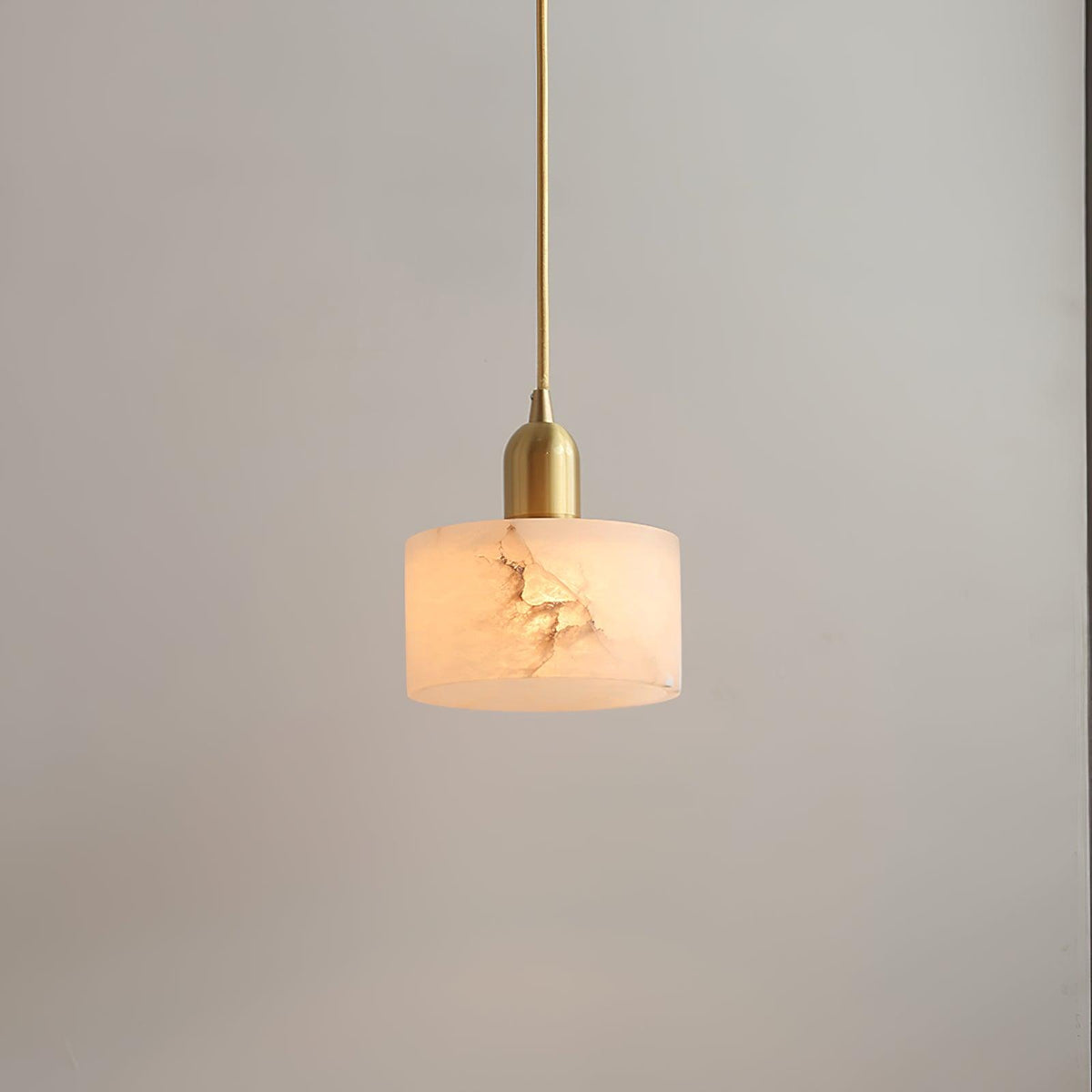 Close view of the lit alabaster shade showing natural stone veining and the brass lamp holder