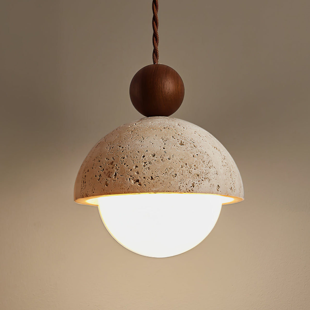 Close view of the Vairo Travertine Dome Pendant Light lit, showing the pitted travertine surface