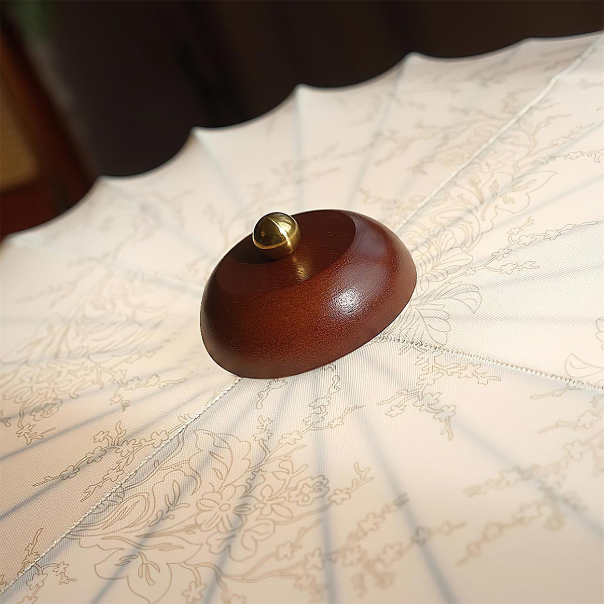 Detail of the turned walnut wood canopy at the centre of the Larso ceiling light