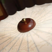 Detail of the turned walnut wood canopy at the centre of the Larso ceiling light