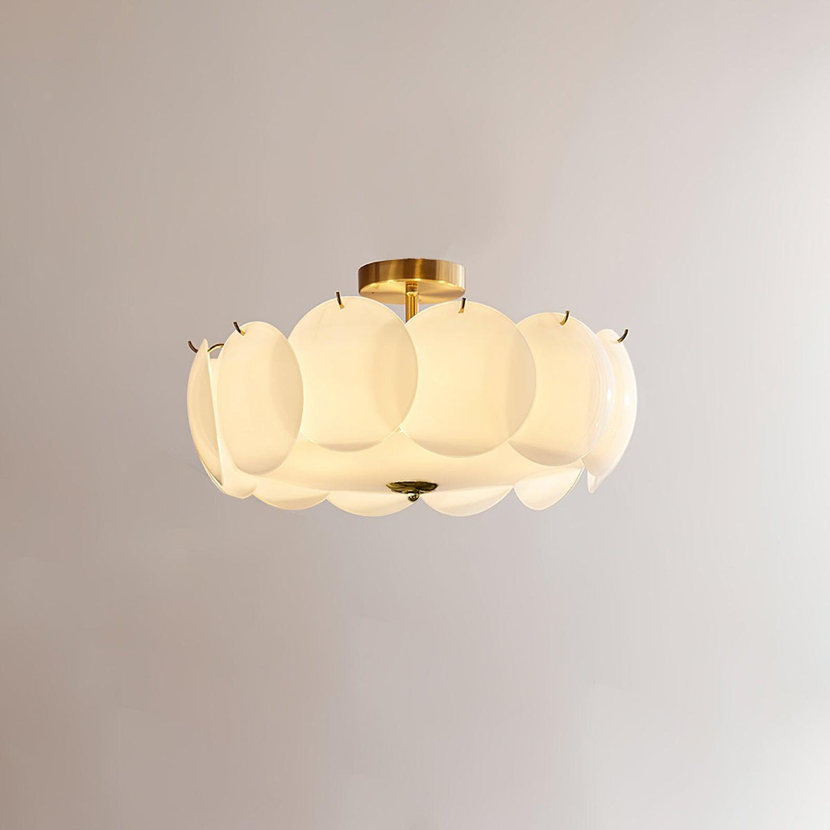 Meho brass and opal glass semi flush ceiling light lit against a plain grey wall