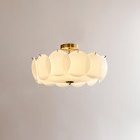Meho brass and opal glass semi flush ceiling light lit against a plain grey wall