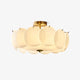 Meho shell ceiling light on a white background, overlapping opal glass discs on a brass frame