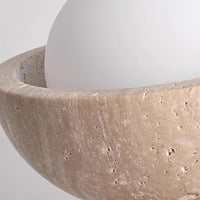 Close-up of the travertine rim and opal glass globe on the Isven ceiling light