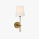 Thedo brass wall light with white tapered fabric shade on a plain wall