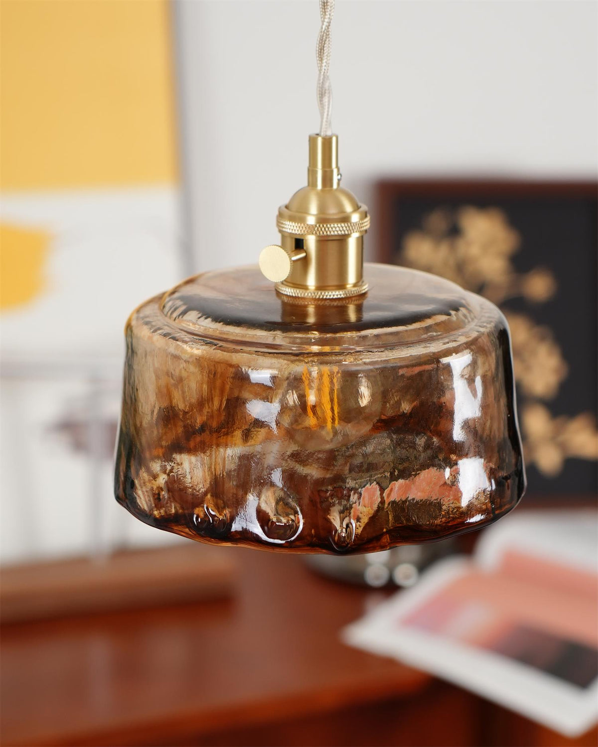Cadro pendant hanging above a wooden console table with brass hardware in view
