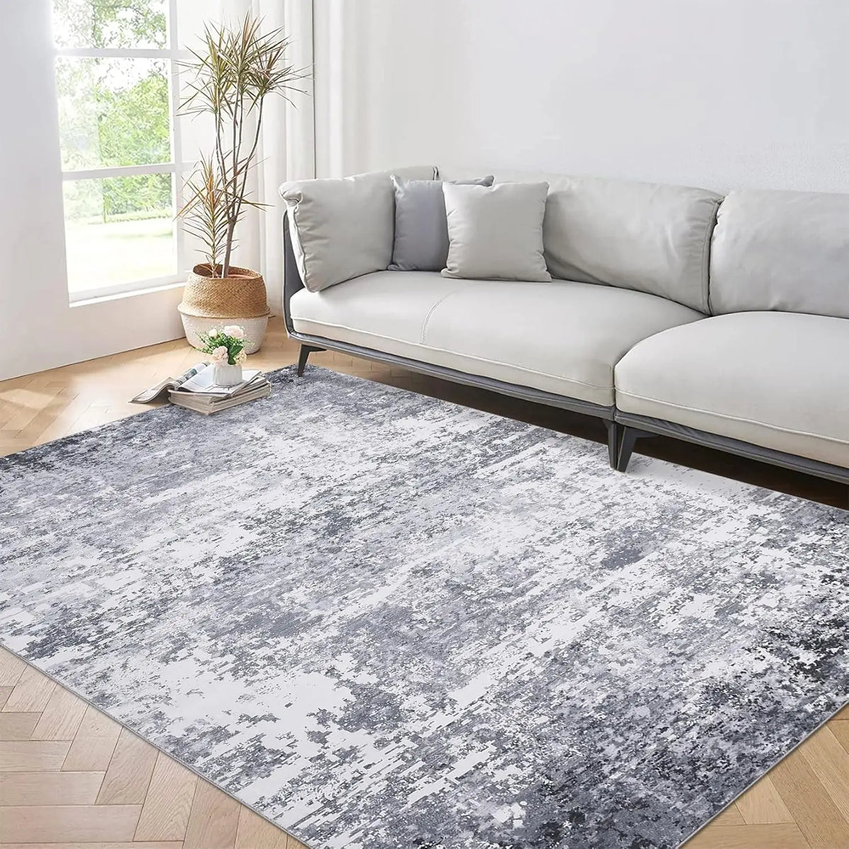 Marlo rug in a bright living room on herringbone oak flooring beside a pale grey sofa