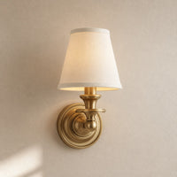 Ruva fabric shade wall light in brass with a white tapered shade on a plain background