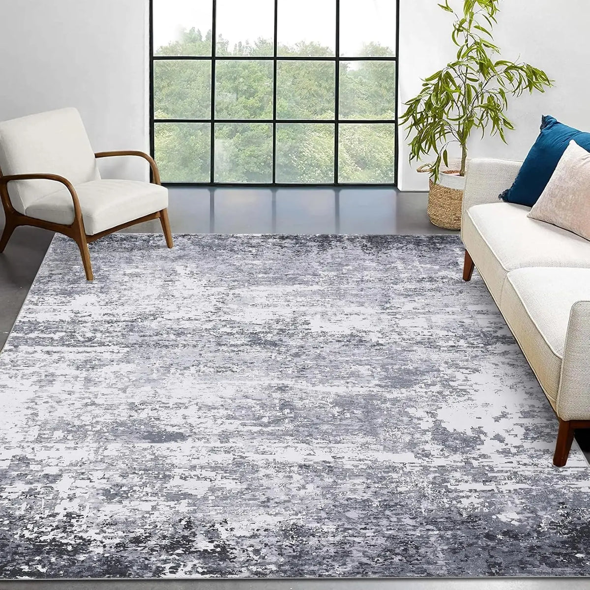 Marlo rug in a living room with a cream sofa and walnut armchair, showing the grey abstract pattern edge to edge