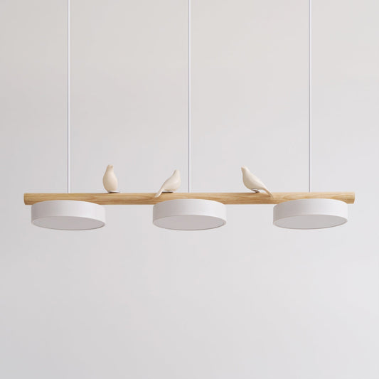 Clifo bird branch linear pendant light on a plain background, natural wood bar with three white disc shades and three cream ceramic birds