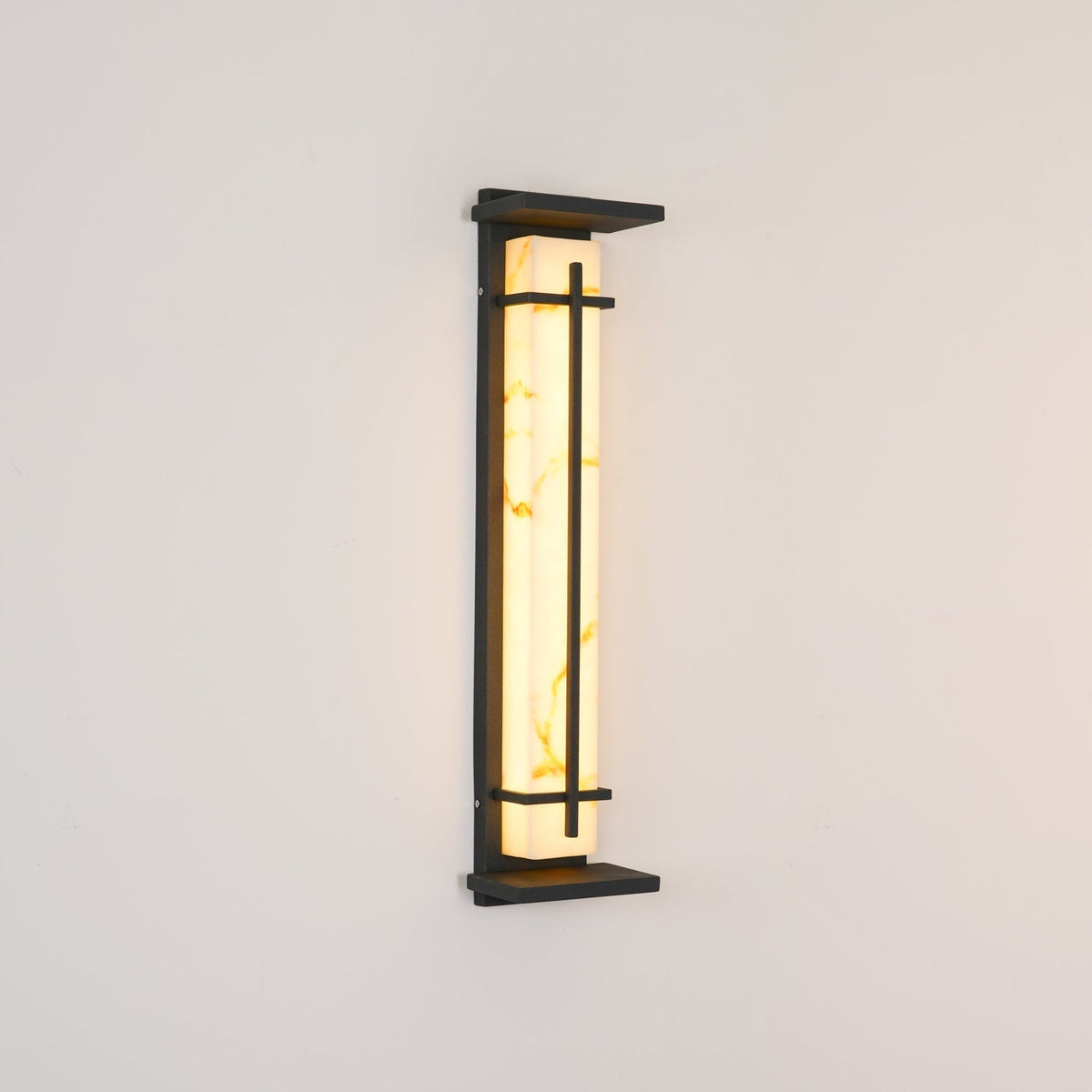 Rayo alabaster wall light shown lit at an angle against a plain wall