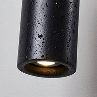 Close view of the Basalo travertine surface and the lit inner face of the cylinder