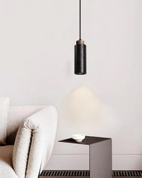 Basalo pendant hanging beside a low console in a pale living room