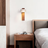Nydo travertine wall light mounted above a bedside table in a bedroom