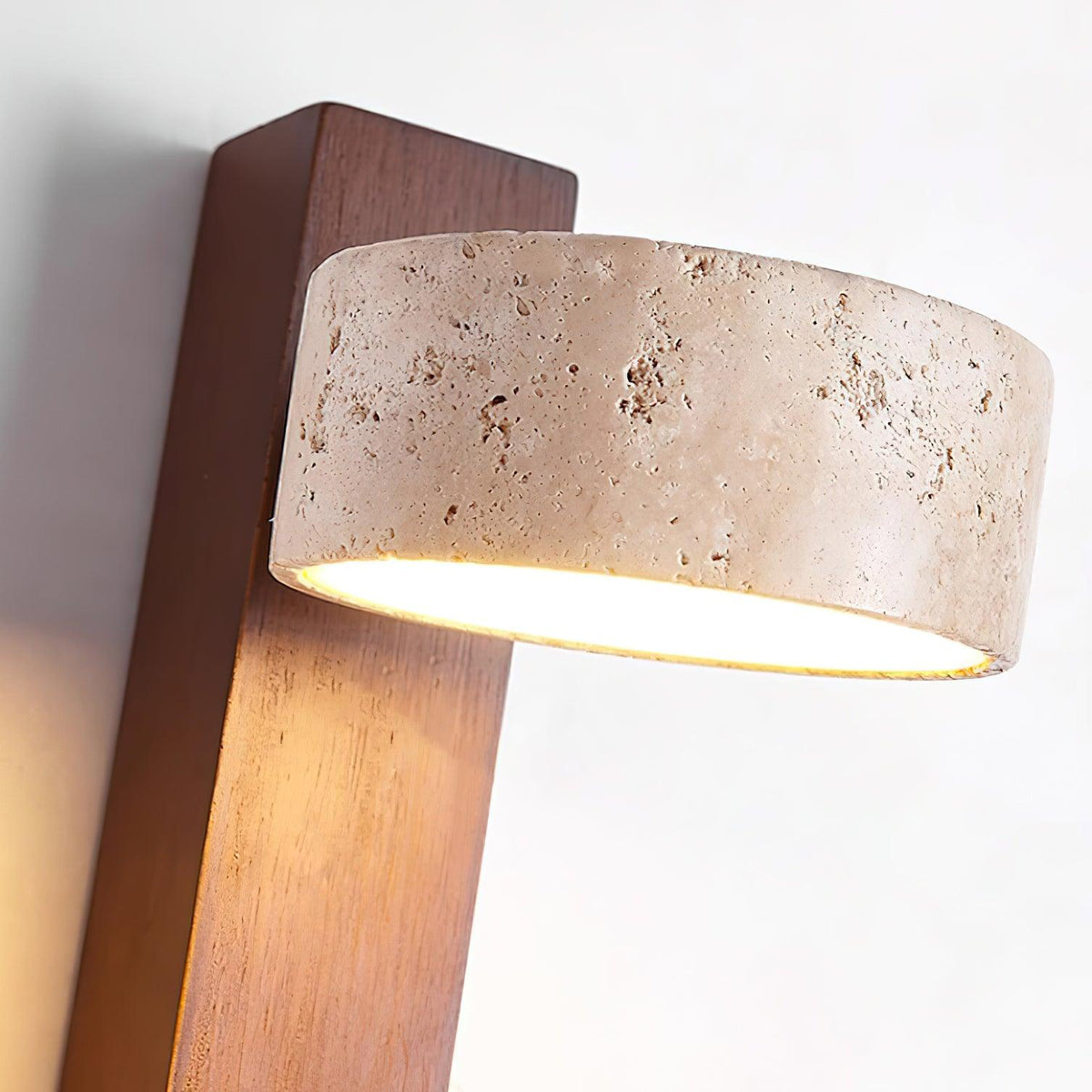 Close up of the pitted travertine shade and walnut beam of the Nydo wall light