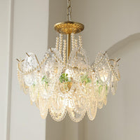 Delvi chandelier lit, showing oval lace pattern glass plaques with a green leaf motif and pearl bead swags