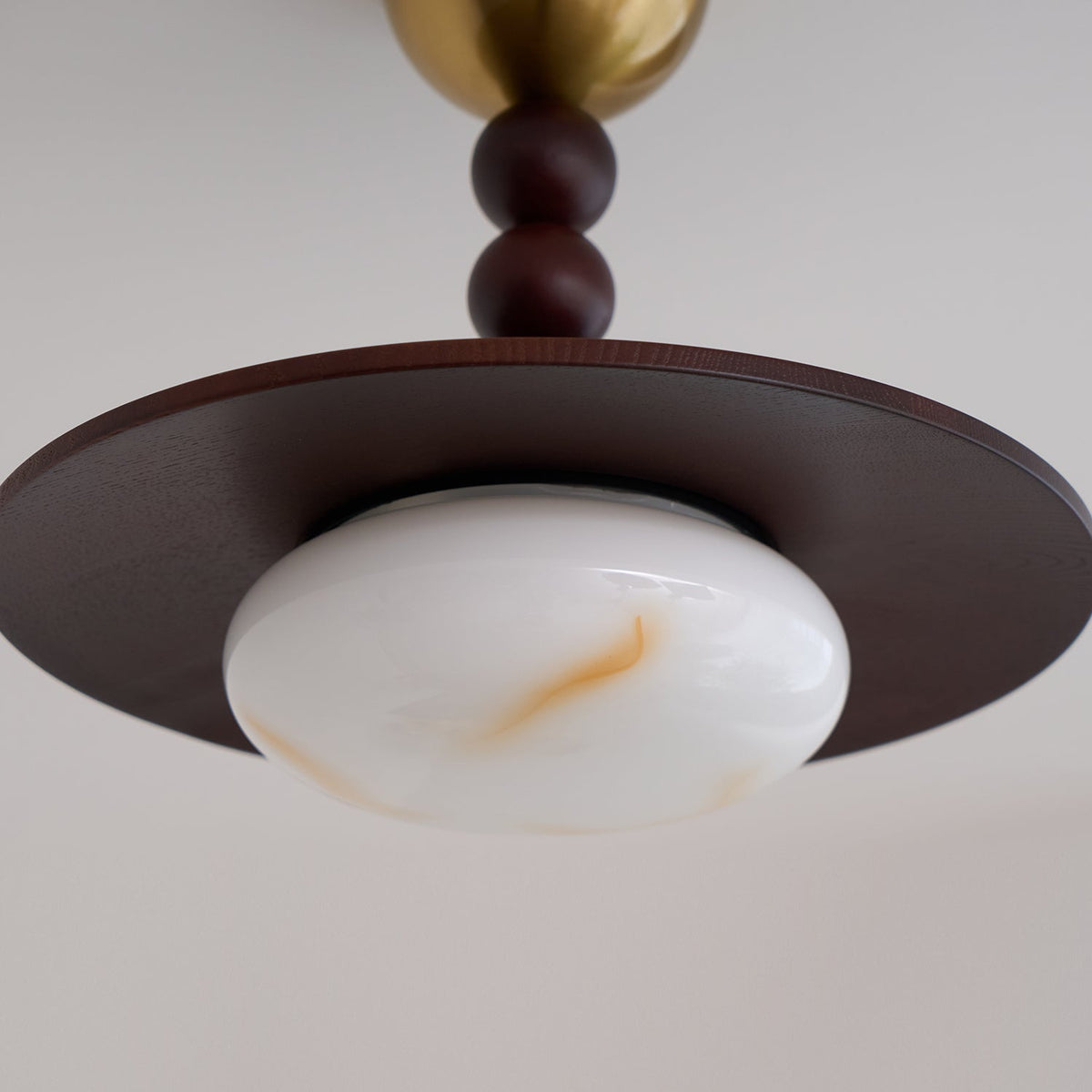 Underside view of the Walo Walnut Alabaster Effect Ceiling Light showing the amber veining in the glass dome
