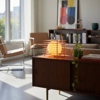 Luno orange table lamp glowing on a walnut sideboard in a bright modern living room