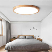 Aveno flush mount ceiling light fitted above a bed in a bright white bedroom