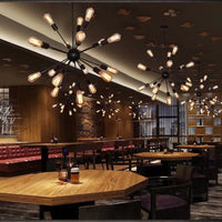 Kytto sputnik chandeliers lit above timber tables in a restaurant dining room