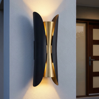 Corva outdoor wall light fitted beside a front door on a rendered exterior wall at dusk, lit up and down