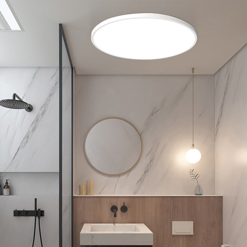 Yano white LED ceiling light fitted in a marble bathroom above a wall hung basin