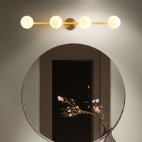 Sevra four light brass bar lit above a round hallway mirror