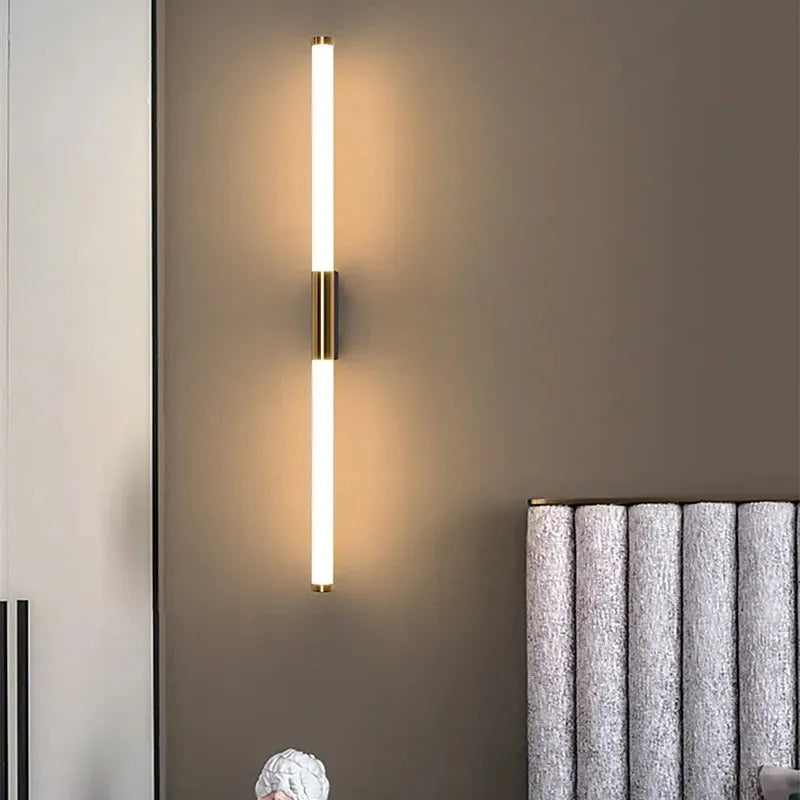 Morva wall light mounted vertically on a dark wall, casting a soft warm glow either side
