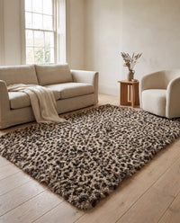 Fauna Shag Rug on pale oak floorboards in a warm neutral living room with an oatmeal linen sofa and a cream boucle armchair