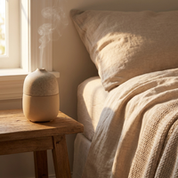 Aura ceramic stone diffuser on a bedroom nightstand with mist