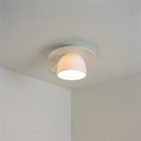 Kupa ceramic teacup ceiling light glowing warm in a bedroom corner