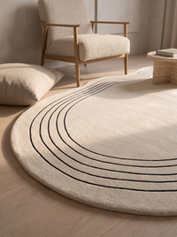 Low angle view of the Ovala rug in a reading nook, showing the pile depth and the black lines curving away across the floor