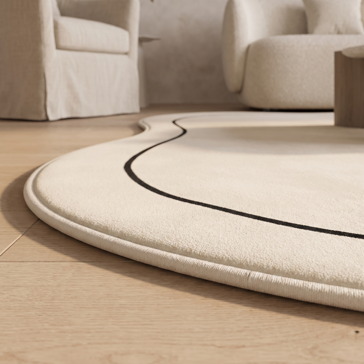 Floor level detail of the Ovala rug edge showing the overlocked binding tape finishing the curved outline against oak flooring