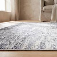 Close-up of the Marlo rug surface showing the low dense pearl-velvet pile and the mottled charcoal, mid-grey and off-white abstract pattern