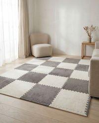 Tessa modular plush rug tiles laid as a checkerboard rug in a warm neutral living room with a boucle armchair, linen sofa and pale oak floor