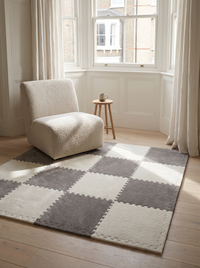 Tessa modular plush rug tiles forming a reading nook underfoot in a period bay window with a boucle chair and oak stool