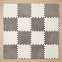 Overhead view of sixteen Tessa modular plush rug tiles assembled into a four by four ivory and grey checkerboard on pale oak floorboards