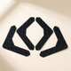 Set of four black L-shaped Gripo rug grippers arranged on a warm off-white background