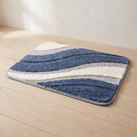 Three quarter studio view of the Nima bath mat laid flat on a pale oak floor against a warm white plaster wall